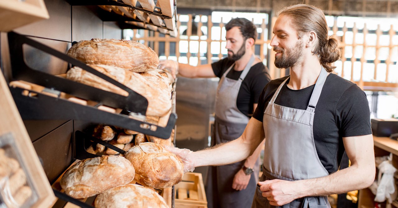 Zwei Bäckerverkäufer arbeiten in der Bäckerei.