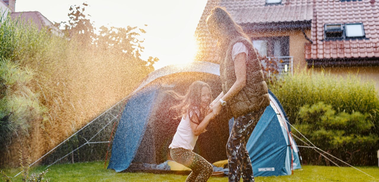Eine Mutter und ein Kind haben Spaß beim Campen im Garten ihres Hauses.